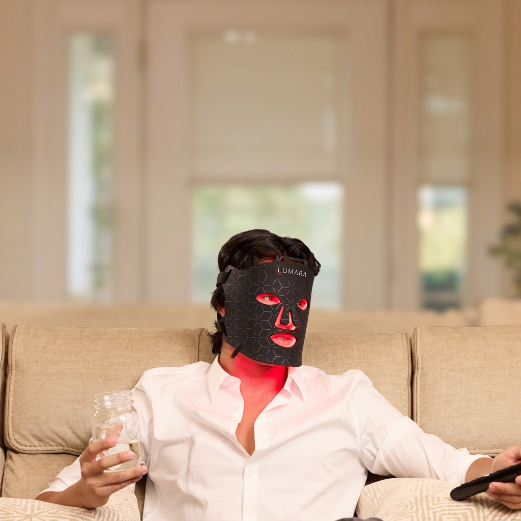Person relaxing on a couch wearing a Lumara VISO LED face mask